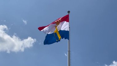 Luxembourg flag with monogram H and crown, flown to celebrate National day and Grand Dukes Henry official birthday. Luxembourg, Luxembourg - June 23, 2022