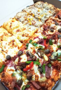 Çeşitli malzemelerle çeşitli pizza dilimleri.