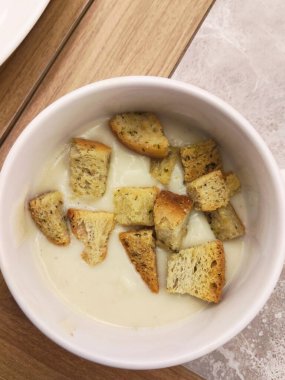 Sıcak ve rahatlatıcı bir kase kremalı çorba üzerine altın kahverengili kızarmış ekmek, lezzetli ve basit bir yemek için mükemmel..