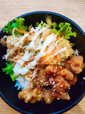 Taze salata, susam tohumu ve baharatlı sosla kaplı lezzetli bir Japon tavuklu teriyaki kasesi..