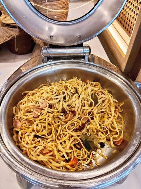 Paslanmaz çelik büfe tepsisinde sebzeli Endonezya usulü kızarmış erişte.