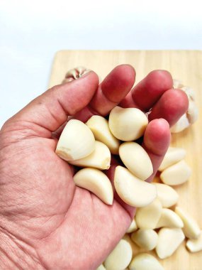 Canlı, taze sarımsak soğanları ve ahşap bir tahtanın üzerinde bir yığın temiz karanfil. Yemek blogları ve sağlıklı yaşam temaları için mükemmel..