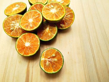 Portakallar ve limonlar da dahil olmak üzere taze kesilmiş turunçgillerin canlı ve detaylı bir yakın çekimi, ahşap bir yüzeye güzelce yerleştirilmiş, canlandırıcı dokularını vurguluyor..