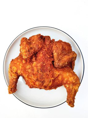 Bakakak Ayam olarak bilinen lezzetli, altın-kahverengimsi, kıtır kıtır kızarmış tavuk beyaz bir yüzey üzerinde sunuluyor, bol bol kırmızı biber tozu ile..