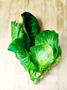 Canlı, taze kailan yeşilliklerinden yakın çekim. Görüntü, sağlıklı, organik ve vejetaryen yemek temaları için mükemmel olan zengin dokuyu ve doğal rengi vurgular..