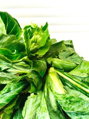 Canlı, taze kailan yeşilliklerinden yakın çekim. Görüntü, sağlıklı, organik ve vejetaryen yemek temaları için mükemmel olan zengin dokuyu ve doğal rengi vurgular..