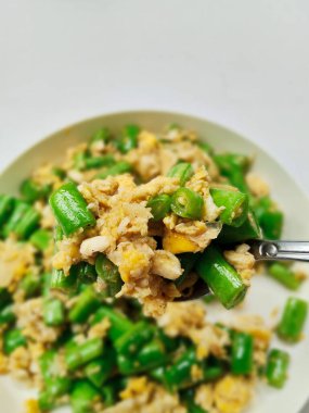 Bir tabak geleneksel Endonezya kızartması. Taze uzun fasulye ve çırpılmış yumurta. Sağlıklı ve basit bir ev yapımı yemek..