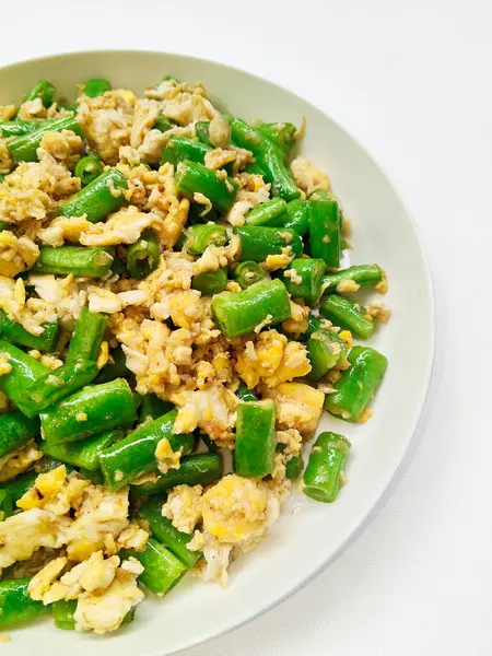 Bir tabak geleneksel Endonezya kızartması. Taze uzun fasulye ve çırpılmış yumurta. Sağlıklı ve basit bir ev yapımı yemek..