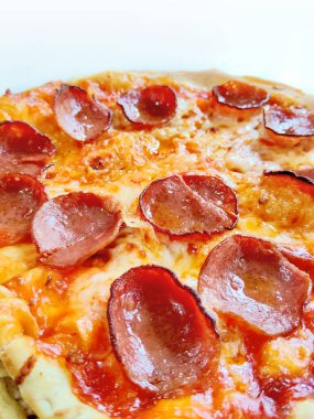 Eritilmiş mozzarella peynirli ve altın hamurlu bir pepperonili pizza kırsal ahşap servis tahtasının üzerinde sunuluyor..