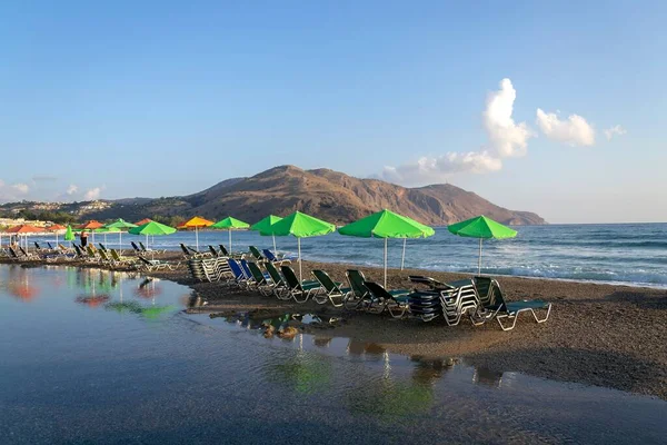 在佐治亚州 克里特岛附近的沙滩半岛上的沙滩上 沙滩躺椅上的遮阳伞下 阳光明媚的夏日黎明时分 放松的概念 蔚蓝清澈的天空复制空间 图库照片