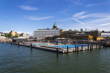 Halk deniz havuzu ve geleneksel saunanın keyfini çıkaran insanlar güneşli bir yaz gününde 8 Temmuz 2024 'te Finlandiya' nın başkenti Helsinki 'de bulunan Katajokanlaituri' de.