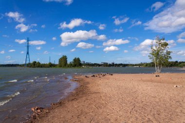 Helsinki, Finlandiya 'nın merkezinde Hietaniemi kumsalı, güneşli bir yaz günü, arka planda elektrik hatları
