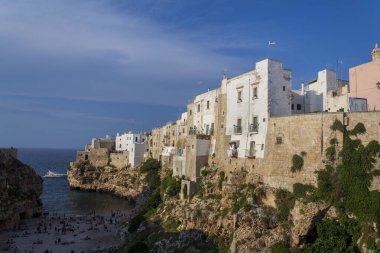 Adriyatik denizinden yükselen dramatik kayalıklardaki geleneksel evler, Polignano 'daki Lama Monachile a Mare, İtalya