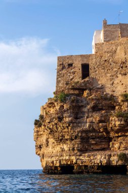 Adriyatik denizinden yükselen dramatik kayalıklardaki geleneksel evler, Polignano 'daki Lama Monachile a Mare, İtalya
