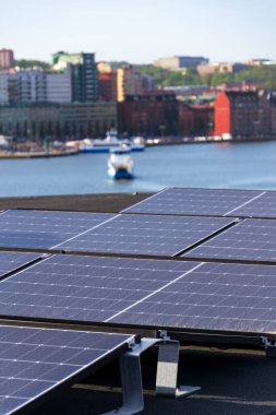 Göteborg şehir merkezi arka planda, İsveç, yenilenebilir yeşil sürdürülebilir enerji kavramı ile apartman binasının çatısında güneş panelleri