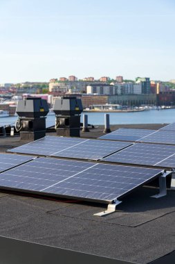 Göteborg şehir merkezi arka planda, İsveç, yenilenebilir yeşil sürdürülebilir enerji kavramı ile apartman binasının çatısında güneş panelleri