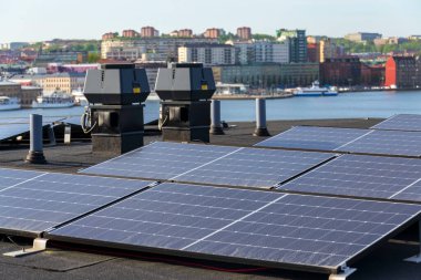 Göteborg şehir merkezi arka planda, İsveç, yenilenebilir yeşil sürdürülebilir enerji kavramı ile apartman binasının çatısında güneş panelleri