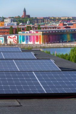 Göteborg şehir merkezi arka planda, İsveç, yenilenebilir yeşil sürdürülebilir enerji kavramı ile apartman binasının çatısında güneş panelleri