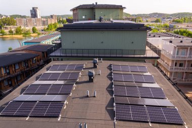 Göteborg şehir merkezi arka planda, İsveç, yenilenebilir yeşil sürdürülebilir enerji kavramı ile apartman binasının çatısında güneş panelleri