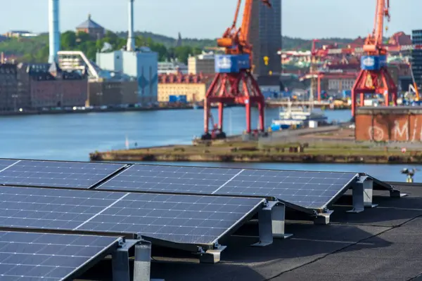 Göteborg şehir merkezi arka planda, İsveç, yenilenebilir yeşil sürdürülebilir enerji kavramı ile apartman binasının çatısında güneş panelleri