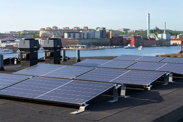 Göteborg şehir merkezi arka planda, İsveç, yenilenebilir yeşil sürdürülebilir enerji kavramı ile apartman binasının çatısında güneş panelleri