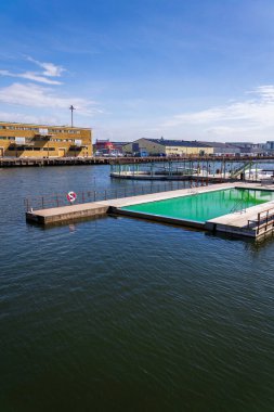 Frihamnen, Gothenburg, İsveç 'teki Allmanna limanında saunayla yüzen yüzme havuzları, güneşli bir gün.