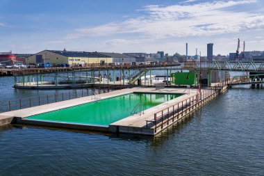 Frihamnen, Gothenburg, İsveç 'teki Allmanna limanında saunayla yüzen yüzme havuzları, güneşli bir gün.