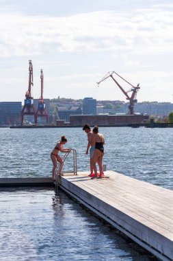 İnsanlar 10 Mayıs 2025 'te İsveç' in Göteborg şehrinde Frihamnen 'deki Allmanna limanında saunayla yüzen havuzlarda yüzüyorlar..