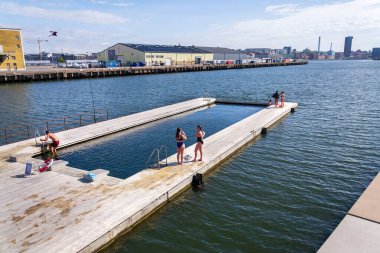 İnsanlar 10 Mayıs 2025 'te İsveç' in Göteborg şehrinde Frihamnen 'deki Allmanna limanında saunayla yüzen havuzlarda yüzüyorlar..