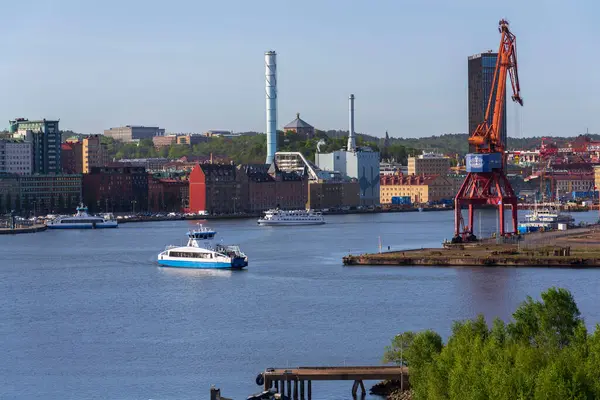 Güneşli bir günde 13 Mayıs 2025 'te İsveç' in Göteborg kentindeki Kvillepiren kentinden Gota Nehri 'ni feribotla geçen şehir silueti..