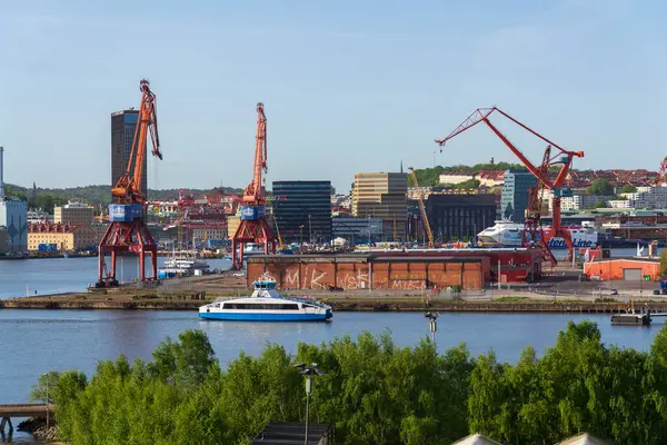 Güneşli bir günde 13 Mayıs 2025 'te İsveç' in Göteborg kentindeki Kvillepiren kentinden Gota Nehri 'ni feribotla geçen şehir silueti..