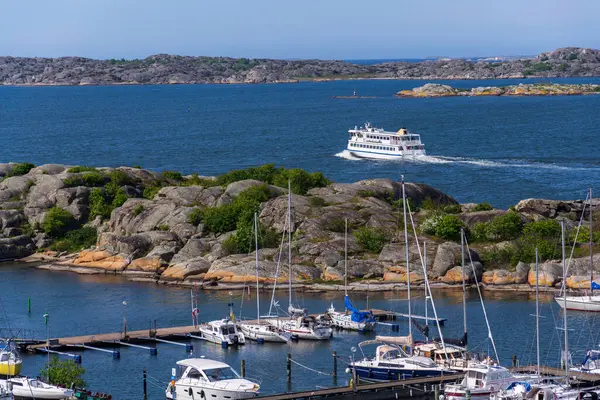 Alvsborgsfjorden, Alvsborg ilçesi, Göteborg, İsveç, güneşli bir günde Saltholmen yarımadasındaki gemilerle birlikte limandan kalkan takımada feribotu.
