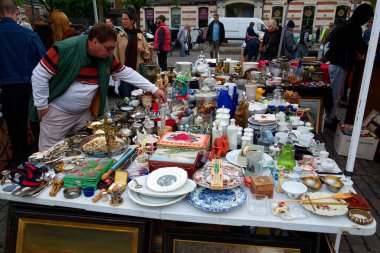 İnsanlar 26 Mayıs 2025 'te Brüksel, Belçika' daki Place du Jeu de Balle 'de bitpazarından eski antika şeyler alıyor..