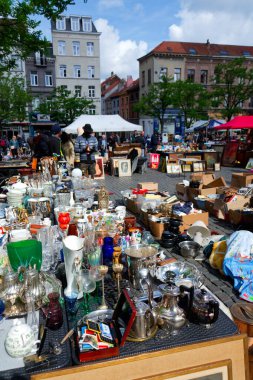 İnsanlar 26 Mayıs 2025 'te Brüksel, Belçika' daki Place du Jeu de Balle 'de bitpazarından eski antika şeyler alıyor..