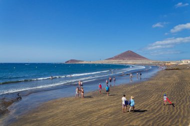 İnsanlar 7 Temmuz 2019 'da İspanya' nın El Medano şehrinde Playa El Medano plajında yüzüyor ve güneşleniyor..