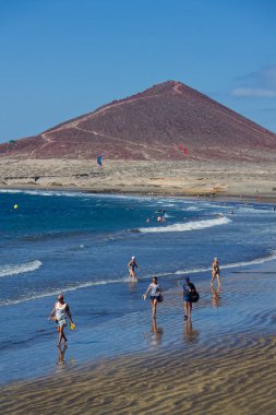 İnsanlar 7 Temmuz 2019 'da İspanya' nın El Medano şehrinde Playa El Medano plajında yüzüyor ve güneşleniyor..