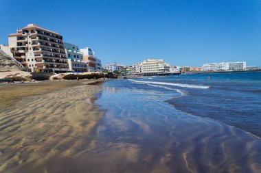 İnsanlar 9 Temmuz 2019 'da İspanya' nın El Medano şehrinde Playa El Medano plajında yüzüyor ve güneşleniyor..