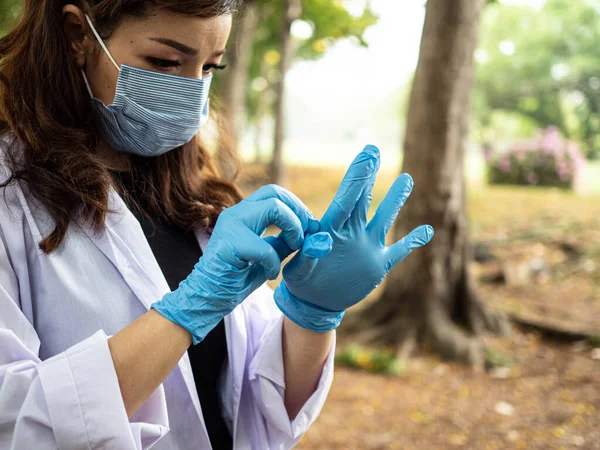 Female woman lady scientist nurse doctor wear mask glove blue research test biology medical health care leaf environment chemical pollution green natural corona virus disease chemistry