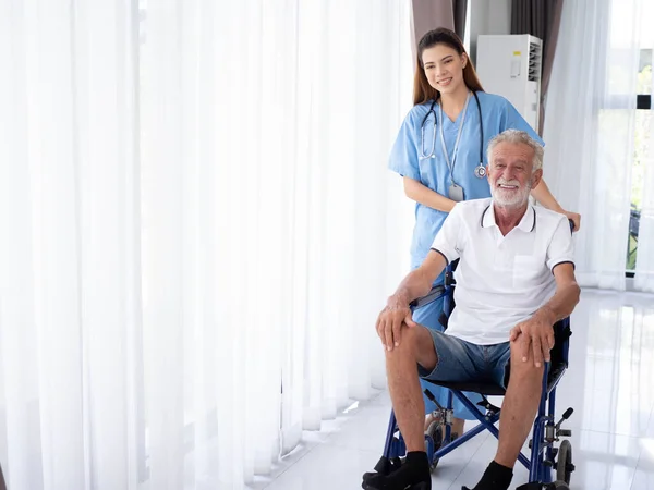 Female woman lady girl person doctor nurse staff assistant health care treatment wheel chair older man people handicap nursing home white isolated background copy space caregiver indoor hospital