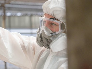 Bilim gözlük takar. Zehirli maske takar. Beyaz üniforma giyer. 