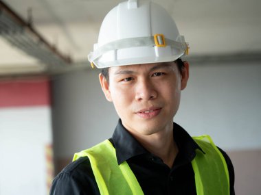 Ustabaşı mühendisi, beyaz kasklı güvenlik kameraya bak yakışıklı, profesyonel, portre teknisyeni yönetici, ekipman kontrol fabrikası fotokopi kontrol servisi kendinden emin.