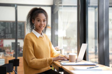 Bilgisayar ve mobil cihaz kullanan genç bir kız öğrenci çevrimiçi çalışıyor. Eğitim ve çevrimiçi öğrenim