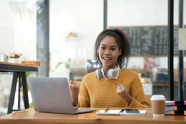 Asyalı kadın bunu dizüstü bilgisayarla kutluyor, başarı pozu veriyor. E-ticaret, üniversite eğitimi, internet teknolojisi, ya da küçük işletme kavramı. Modern ofis veya oturma odası fotokopi alanı.