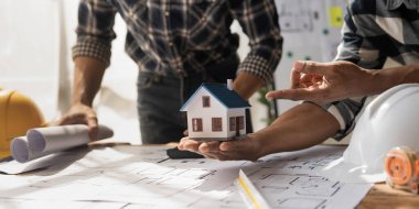 Mimarlar, mühendis elinde kalem tutan ekipman mimarları ofiste bir planla, Vintage, Sunset Light. Seçici Odaklanma.