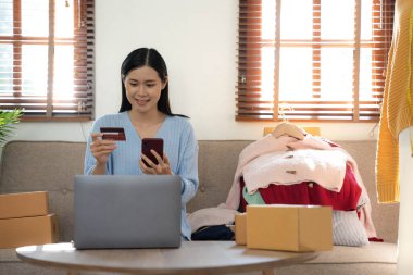 Küçük işletme girişimcisi KME, Asyalı kadın paketleme kutusu. Ev ofisteki Asyalı küçük işletme sahibinin portresi, çevrimiçi pazarlama dağıtımı