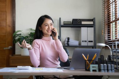 Gülümseyen Asyalı iş kadını. Çizelgeyi ve grafiği analiz ediyor. Piyasadaki değişiklikleri gösteriyor....