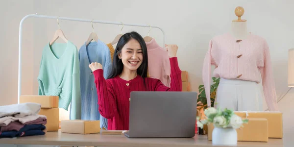 Asian SME business women use laptop computer checking customer order online shipping boxes at home. Starting Small business entrepreneur SME freelance.
