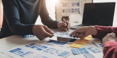 Beyin Fırtınası Konsepti Çalışanları Grubu. İş ekibi beyin fırtınası yapıyor. Pazarlama planı araştırması. Evraklar masada, bilgisayarda ve cep telefonunda.