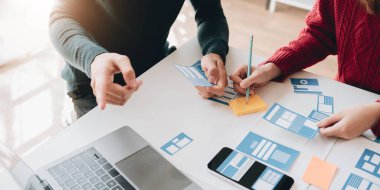Beyin Fırtınası Konsepti Çalışanları Grubu. İş ekibi beyin fırtınası yapıyor. Pazarlama planı araştırması. Evraklar masada, bilgisayarda ve cep telefonunda.