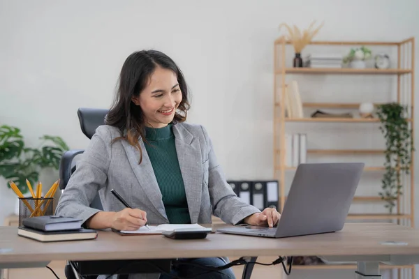 stock image Asian Business woman using calculator and laptop for doing math finance on an office desk, tax, report, accounting, statistics, and analytical research concept..